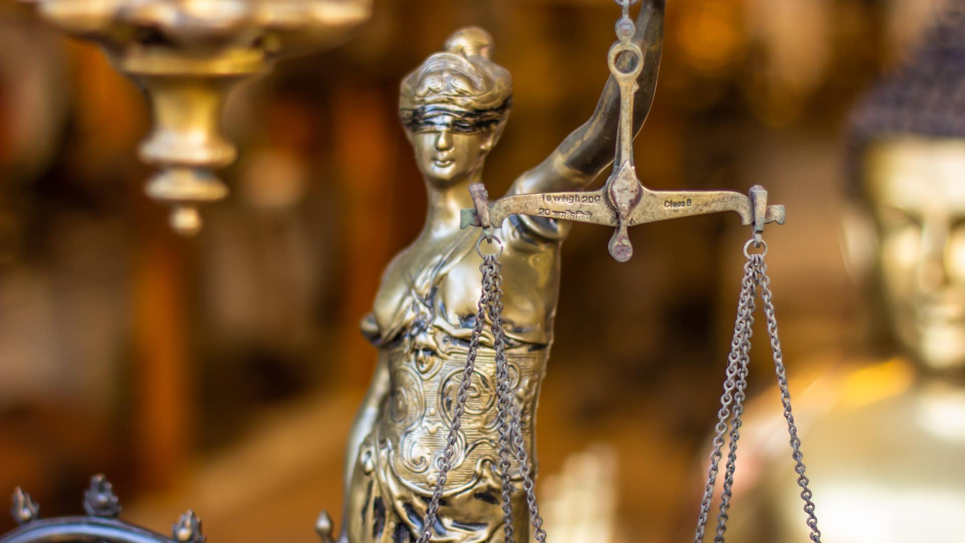 pexels-jaiju-jacob-6593883 Golden statue of Lady Justice holding a set of scales, symbolizing justice and fairness in a market or shop setting